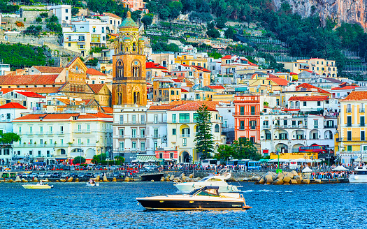 Scenery with yacht on Amalfi coast town at Tyrrhenian sea in autumn. Amalfitana coastline in Italy. Italian summer with beautiful blue water. Panoramic view. Holiday and vacation. Landscape.