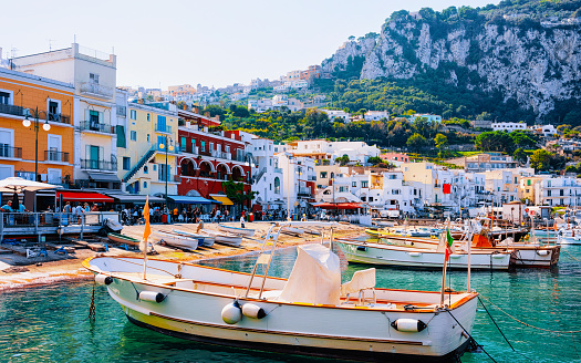 Marina Grande with boats and yachts on Capri Island at Naples in Italy. Landscape with Sea at Italian coast. Anacapri in Europe on summer. Amalfi scenery. Street cafe and restaurants with terraces