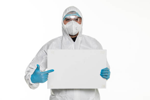 istock Doctor man with protective clothing and goggles with white blank isolated on white background 1218981685