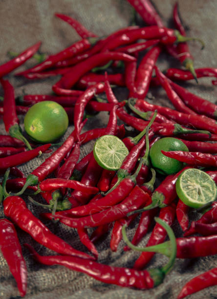 istock Red hot chilli peppers with lime on burlap sack 1218981821