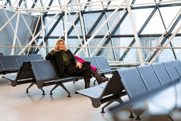 istock Woman using a mobile phone at the airport 1218982838