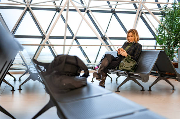 istock Woman using a mobile phone at the airport 1218982912