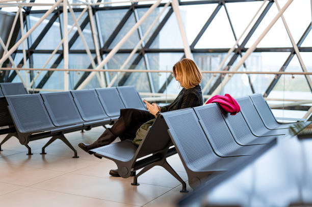 istock Woman using a mobile phone at the airport 1218983014
