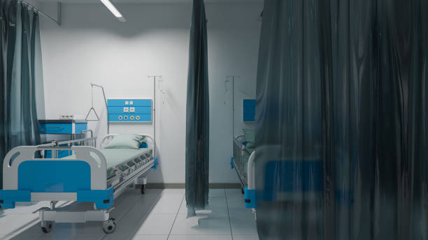 istock Empty Patient Beds Inside a Partially Illuminated Hospital Ward 1218983637