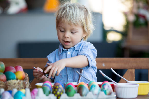 庭でイースターのための甘い子供、兄弟、��着色と絵画の卵、裏庭の自宅で屋外 - playground cute baby blue ストックフォトと画像