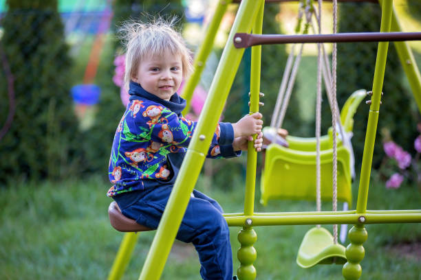 istock Sweet toddler boy, swinging on a swing in backyard 1218983977