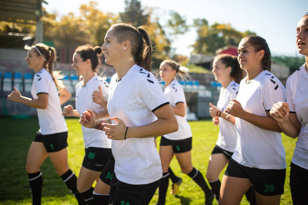 istock Female soccer team warming up before practice on soccer field 1218985230