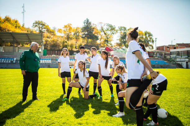 istock Coach and female soccer team talking before training on soccer field 1218985405