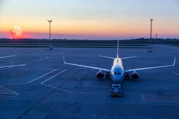 istock the plane with the airfield tractor on the sunset 1218985740