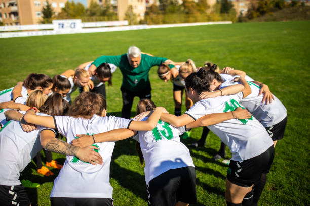 istock Female soccer team huddling with their coach before training 1218985793