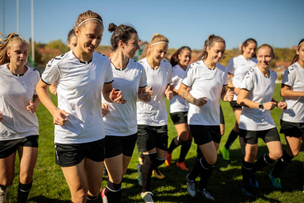 istock Female soccer team warming up before practice on soccer field 1218985944