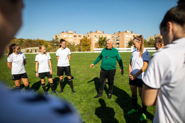 istock Coach and female soccer team talking before training on soccer field 1218985989