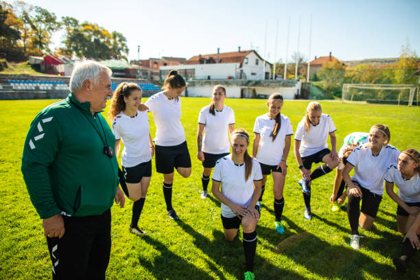 istock Coach and female soccer team talking before training on soccer field 1218986060