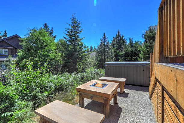 Small open to greenery back yard space with fire and hot tub and wooden deck
