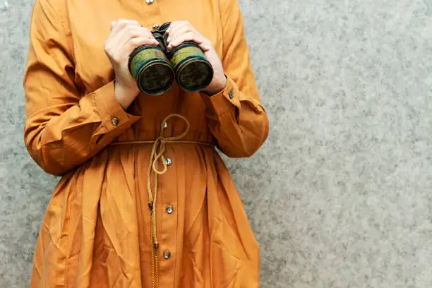 Photo of woman holding  military old binocular, Discovery Equipment. Columbus Day Concept.