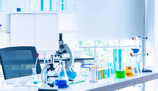 Preparación de equipos de laboratorio microscopio tubo de cristalería con líquido azul en la mesa blanca. El experimento de reseach para descubrir la nueva vacuna contra el virus en laboratorio - foto de stock