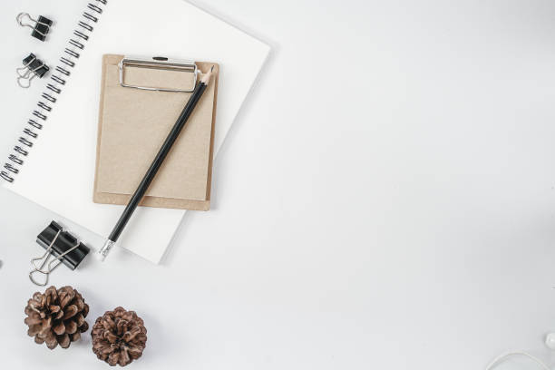istock White office desk table with blank notebook, computer keyboard and other office supplies. Top view with copy space, flat lay. 1218991257