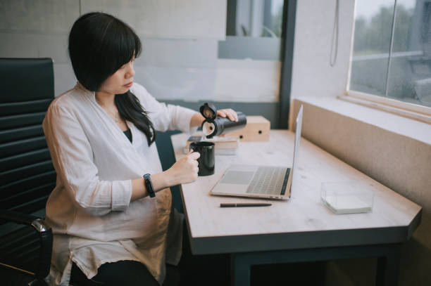 istock an asian pregnant white collar worker in her office cubicle 1218992637
