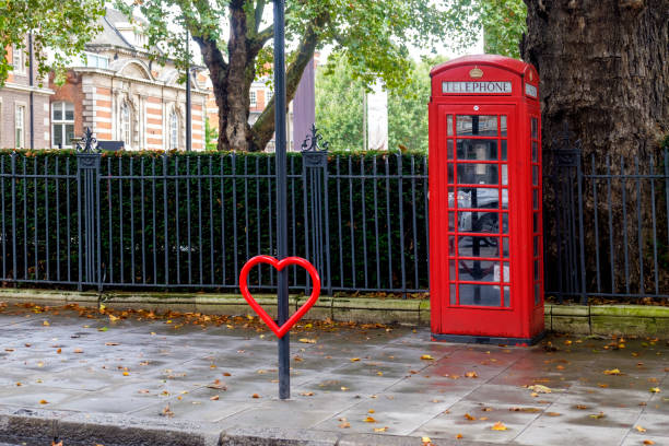 Classic British red colored pay telephone booths in London, England, UK.