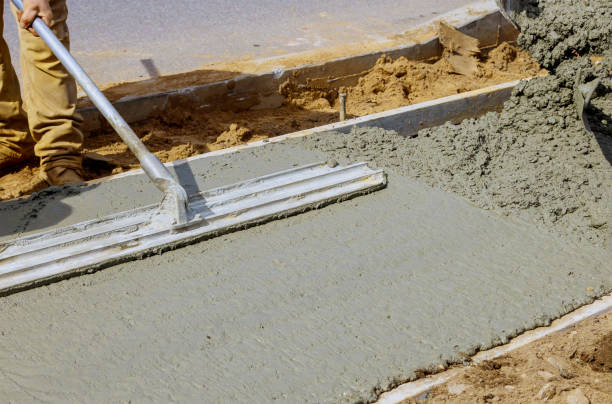 istock Construction worker pour cement for sidewalk in concrete works with wheelbarrow 1218993405