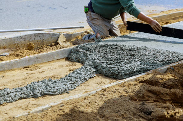 istock Construction workers laying concrete mixer with concrete mixer on sidewalk 1218993407