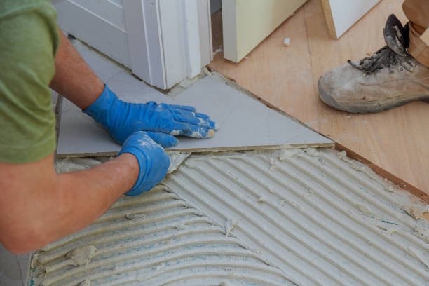 istock Tiler and plaster repair work laying tile, trowel in a man hand 1218993441
