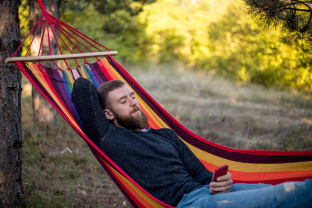 istock Caucasian man lying on hammock in a pine forest. Outdoors relaxation. 1218993840