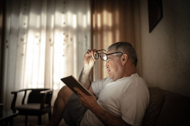 Exhausted / worried senior man using a digital tablet at home
