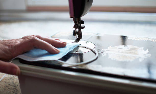istock Volunteers and workers making surgical mask at home. 1218996894