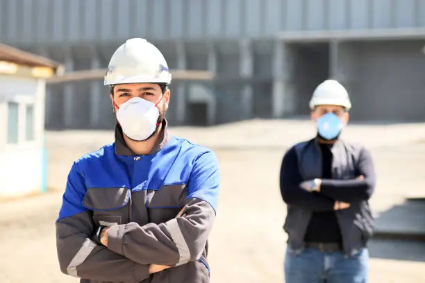 The young civil engineers are working with protective mask in the construction field.