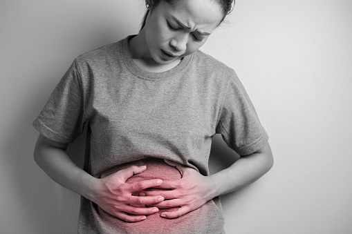 Woman having painful stomach ache. Young woman with abdominal pain due to menstruation. Abdominal pain due to gastritis.