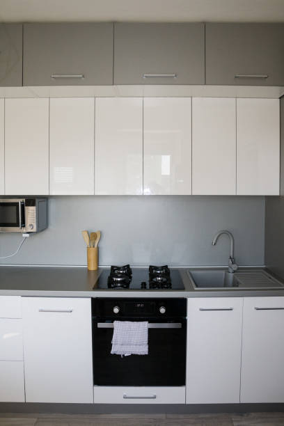 istock Scandinavian, Minimalism Home. White Kitchen Design.  Modern white shiny kitchen with the silver accent and accessories. 1219002012