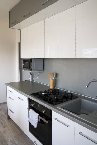 istock Scandinavian, Minimalism Home. White Kitchen Design.  Modern white shiny kitchen with the silver accent and accessories. 1219002024