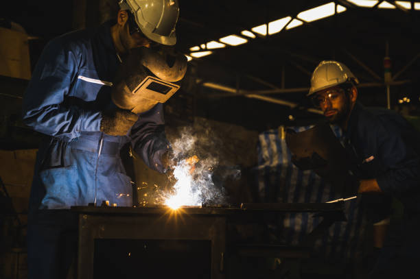 istock Industrial worker welding metal with many sharp sparks 1219003674