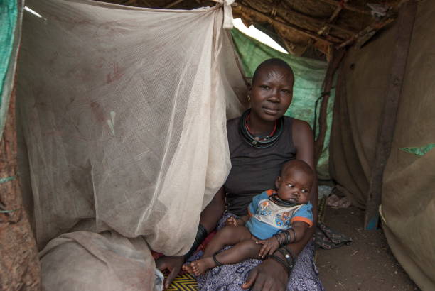 frau mit baby im lager der vertriebenen, juba, südsudan. - mosquito netting stock-fotos und bilder