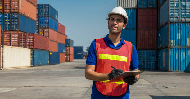 istock Foreman holding clipboard working at Container cargo harbor. Business Logistics import export shipping concept. 1219005337