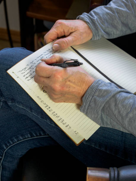 istock Senior Woman Bedroom Writing Left Handed in Diary 1219005368