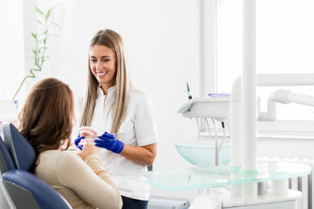 Female dentist explaining how new dentals will work stock photo