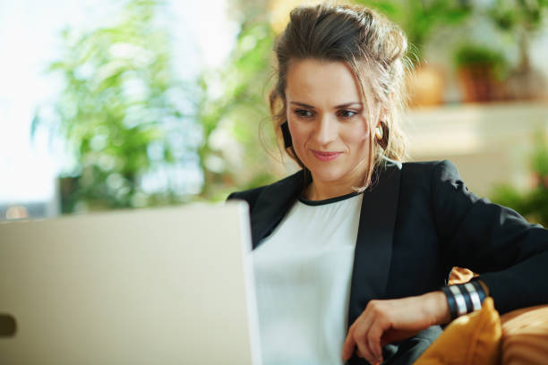 istock stylish woman checking website while sitting on divan 1219007222
