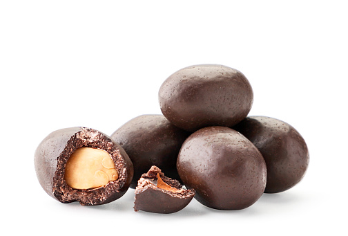 A pile of peanuts in chocolate whole and half on a white background. Isolated