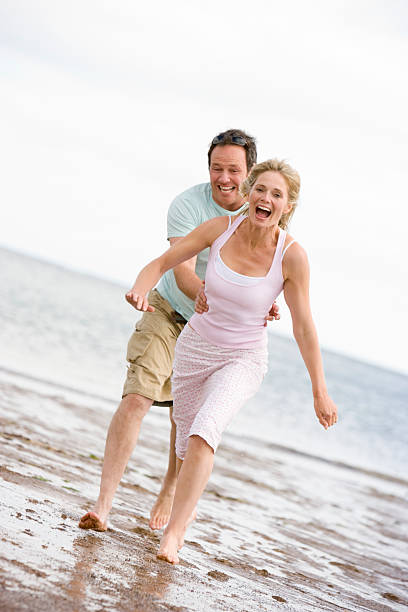 istock Couple running at the beach smiling 121900869