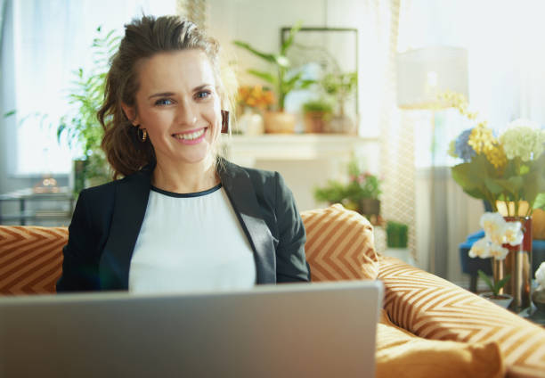 istock happy modern woman surfing web while sitting on sofa 1219009217