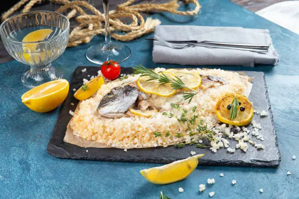 Dorado fish cooked in salt on a blue background