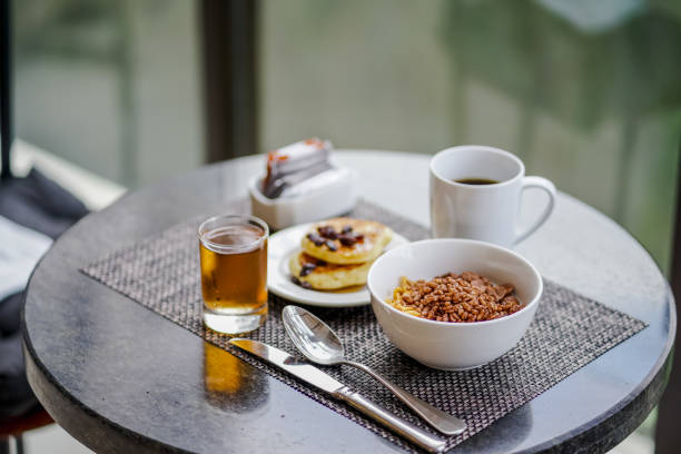 набор для завтрака: чаша хлопьев, блины, чашка кофе и яблочного сока. - oatmeal heat bowl breakfast стоковые фото и изображения