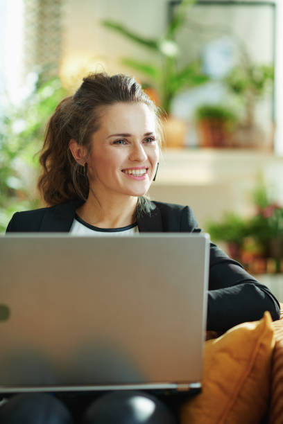 istock happy modern woman and surfing web while sitting on couch 1219013531