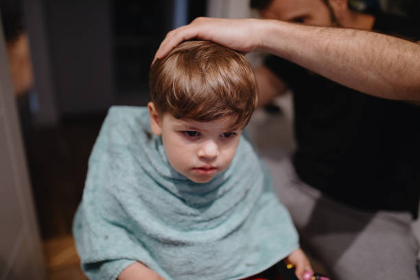 istock Father cutting son's hair at home during isolation 1219013711