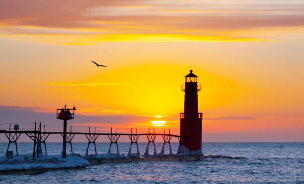 istock Iconic Lighthouse in icy cold harbor, silhouetted against dawn sky. 1219013865