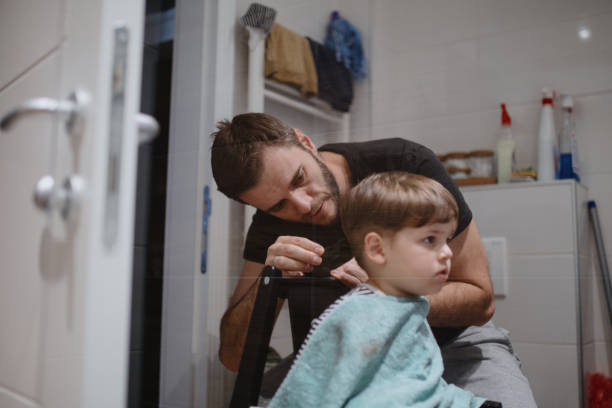 istock Father cutting son's hair at home during isolation 1219013866