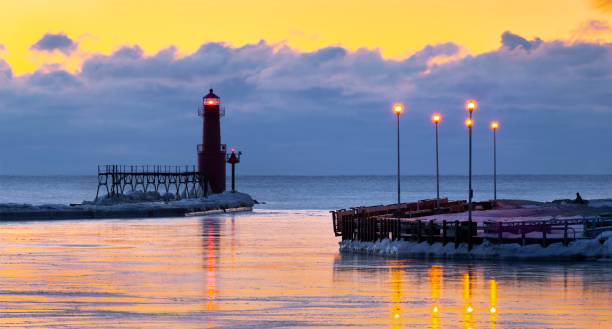 istock Iconic Lighthouse in icy cold harbor, silhouetted against dawn sky. 1219013885