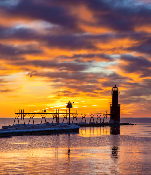 istock Iconic Lighthouse in icy cold harbor, silhouetted against dawn sky. 1219013966
